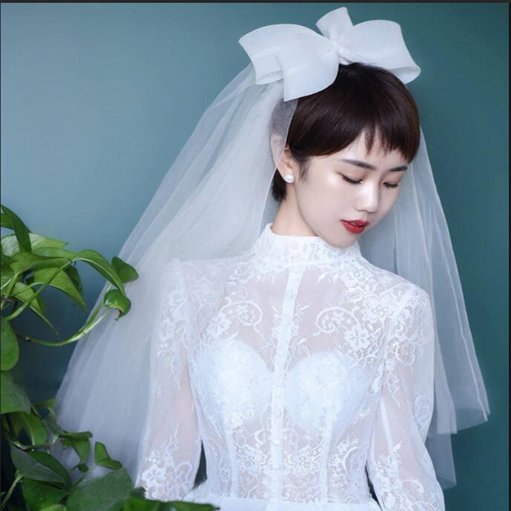 https://nirvana14.com/cdn/shop/products/Bow-Wedding-Veil-Short-Soft-Tulle-Bridal-Veils-Two-Layer-Cheap-Ivory-White-Bride-Veils-Wedding_2000x.jpg?v=1617873215